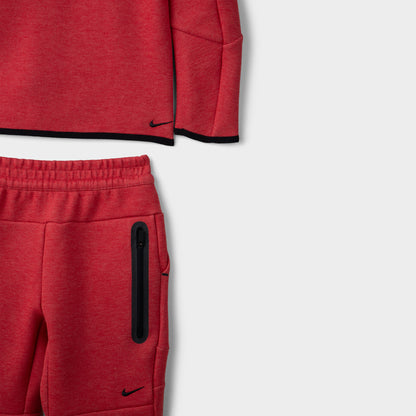 Nike Children's Sportswear Tech Fleece Full Zip Hoodie Set. Close-up of light university red and heather joggers showing elastic waistband, zip pocket and black Nike logo.