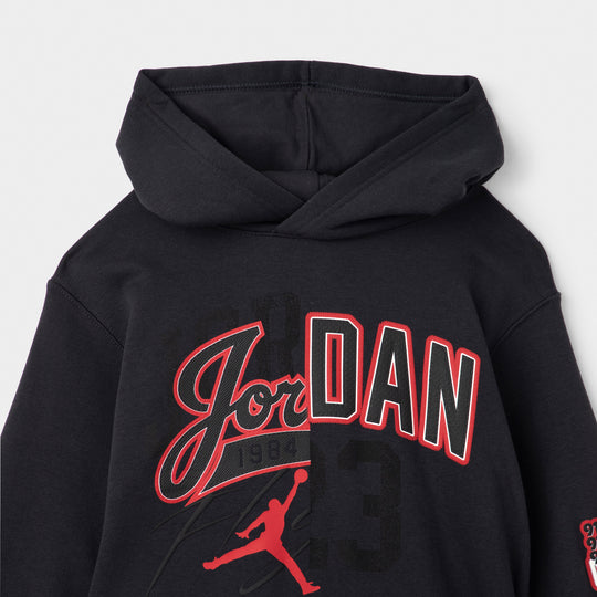 Jordan Juniors' Varsity Split Pullover Hoodie. Close-up of off noir hoodie showing the gym red Jordan script and Jumpman graphic across the chest.