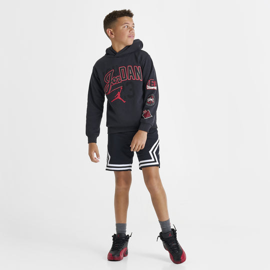 Jordan Juniors' Varsity Split Pullover Hoodie. Full-body front view of model wearing off noir hoodie with black shorts and sneakers.