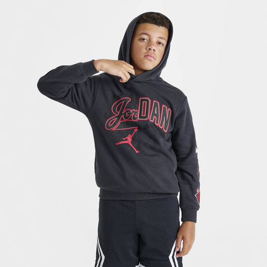 Jordan Juniors' Varsity Split Pullover Hoodie. Front view of model wearing off noir and gym red hoodie with large Jordan script and Jumpman graphic across the chest.