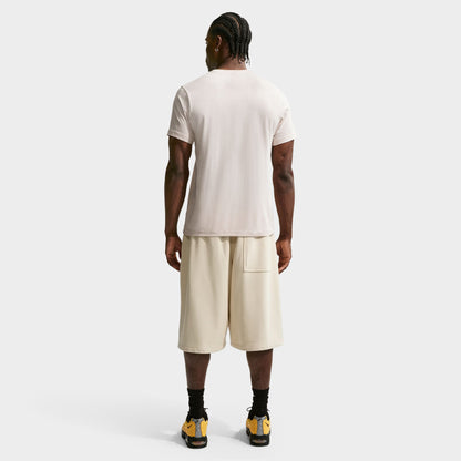 Nike Sportswear Club Tee. Full-body back view of model wearing light orewood brown T-shirt with matching shorts and dark shoes.