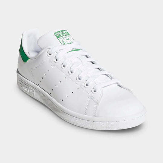adidas Women's Stan Smith. Three-quarter view of white and green sneaker with white laces, perforated side panels and green accents.