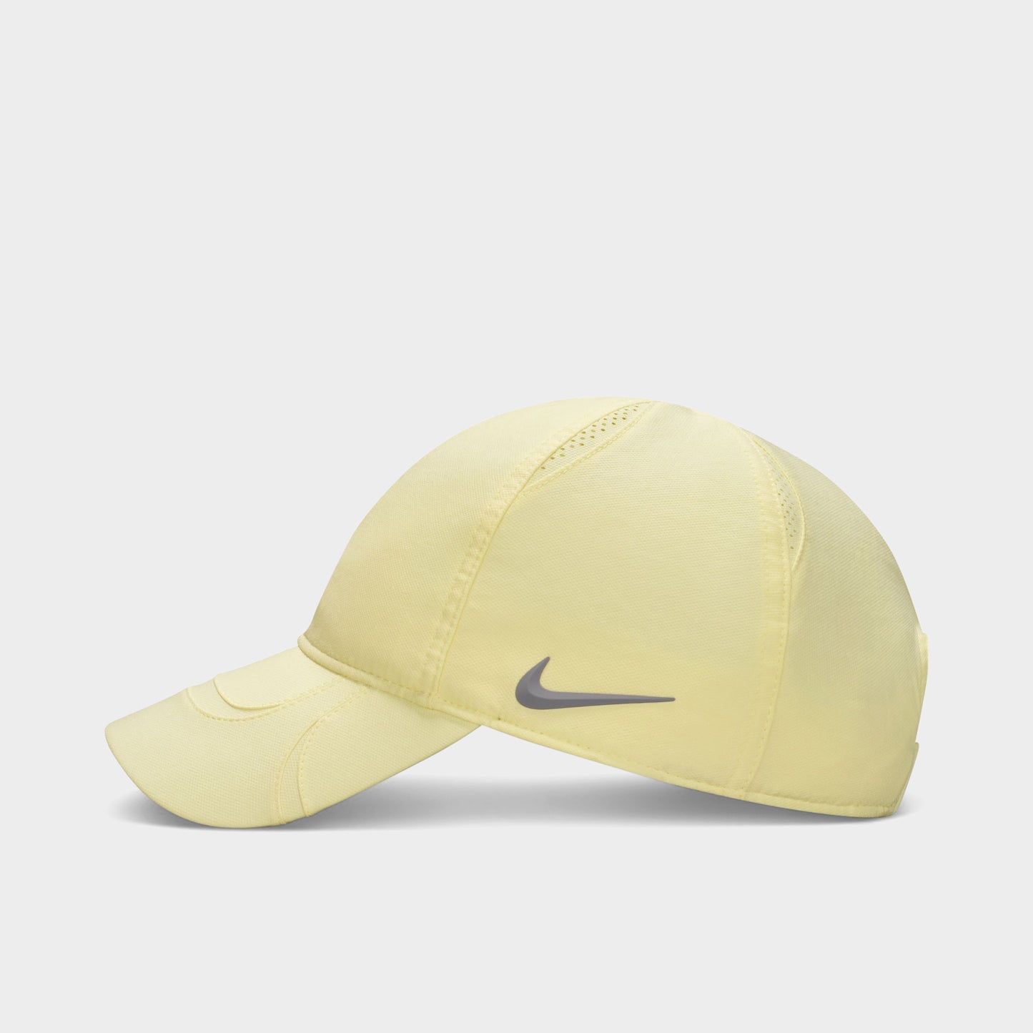 Nike NOCTA S.S.C. Cap CS. Side view of alabaster and platinum tint cap showing curved brim and tonal Nike Swoosh.
