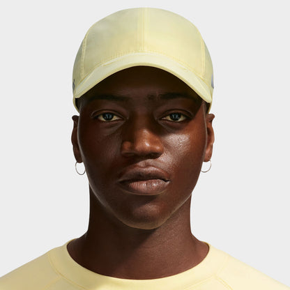 Nike NOCTA S.S.C. Cap CS. Front view of model wearing alabaster and platinum tint cap with curved brim and tonal Nike branding.