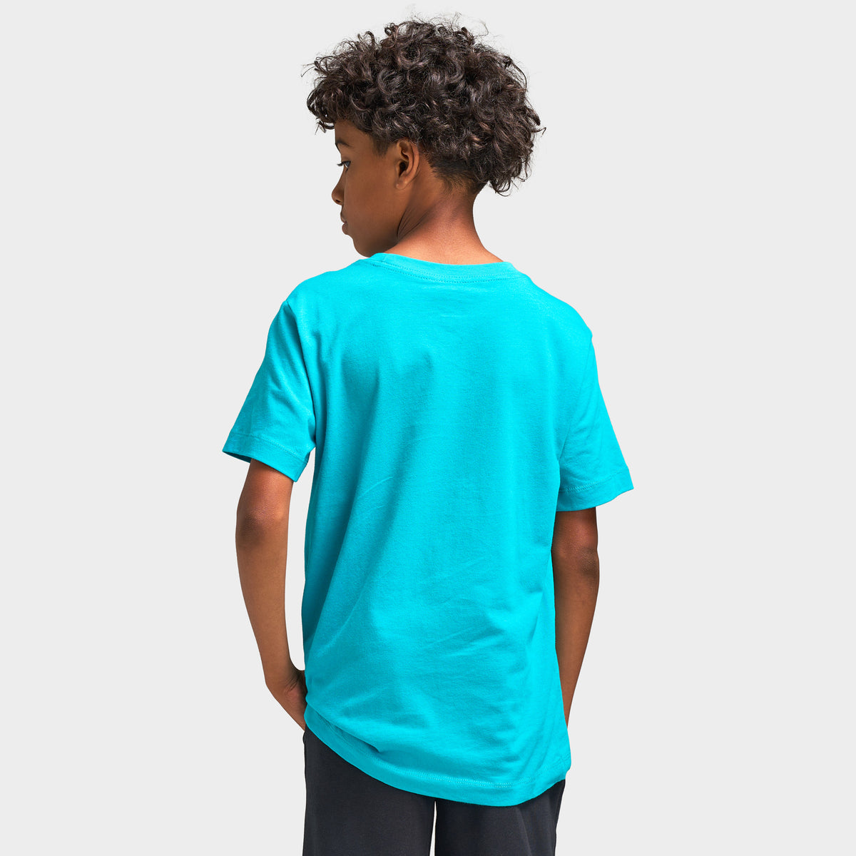 Nike Juniors' Futura T-Shirt. Upper body rear model view showing the back of the energy green turquoise cotton shortsleeve t-shirt, ribbed crewneck collar, set-in sleeves, and straight hem.