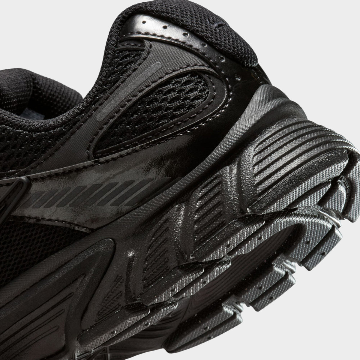 Nike Women's V5 RNR. Close-up of black and anthracite sneaker showing layered heel panels, tonal Swoosh and textured outsole edge.