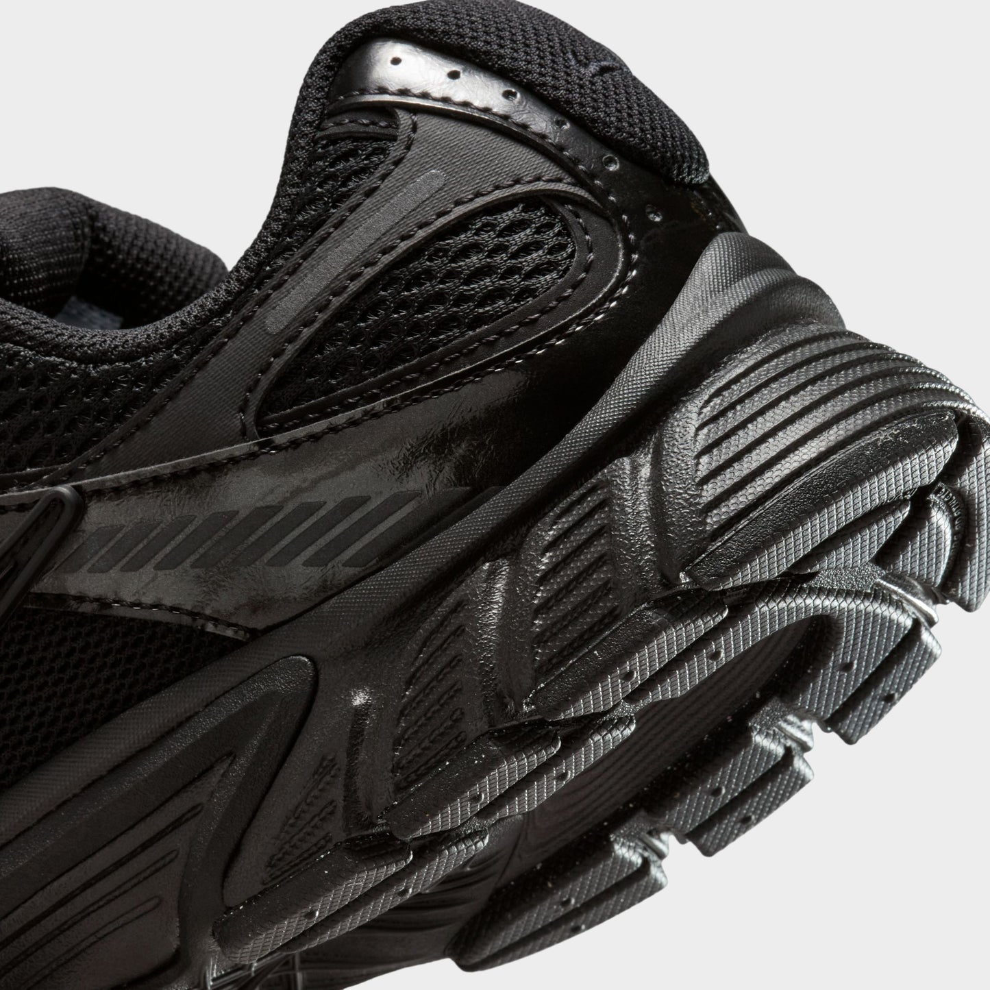 Nike Women's V5 RNR. Close-up of black and anthracite sneaker showing layered heel panels, tonal Swoosh and textured outsole edge.