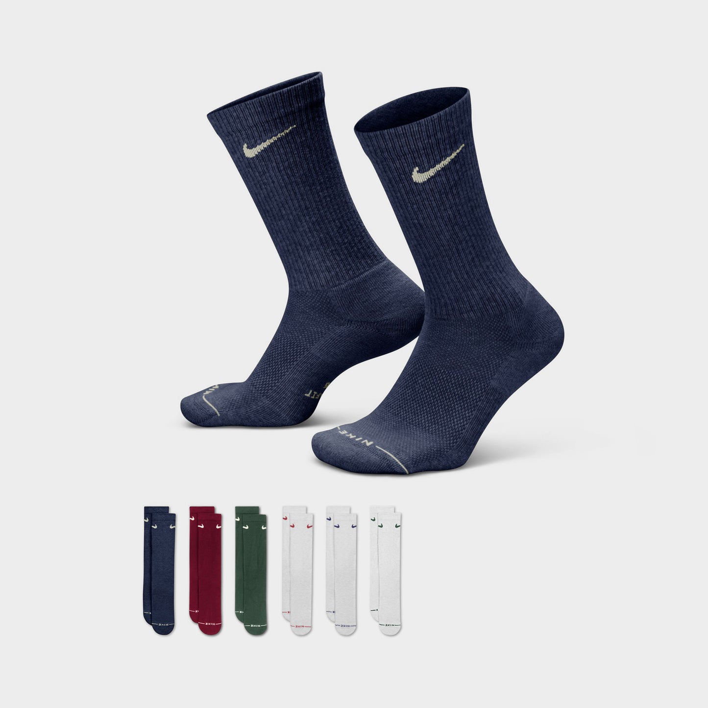 Nike Everyday Elevated Crew Socks (6-Pack). Three-quarter view of navy crew socks beside the multicolour sock assortment.