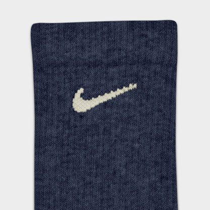 Nike Everyday Elevated Crew Socks (6-Pack). Close-up of navy crew sock showing ribbed knit texture and cream Nike Swoosh logo.