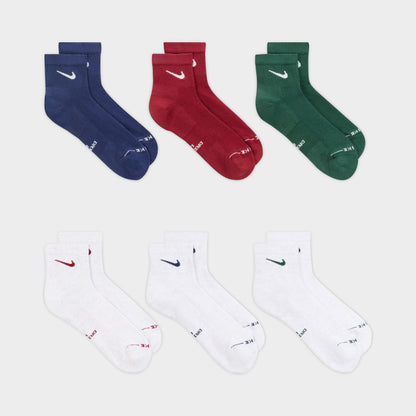 Nike Everyday Elevated Ankle Socks (6-Pack). Flat-lay view of multicolour ankle socks arranged in navy, red, green and white pairs.