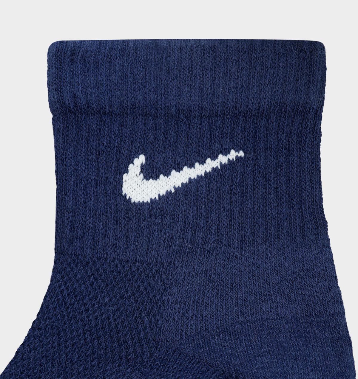 Nike Everyday Elevated Ankle Socks (6-Pack). Close-up of navy ankle sock showing ribbed knit texture and white Nike Swoosh logo.