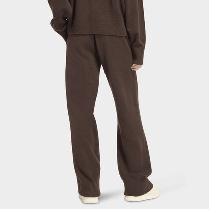 adidas Essentials Knit Pant. Back view of model wearing aurora coffee pants with wide legs and elastic waistband.