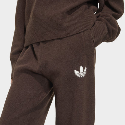 adidas Essentials Knit Pant. Close-up of aurora coffee pants showing white Trefoil logo, side pocket and knit texture.