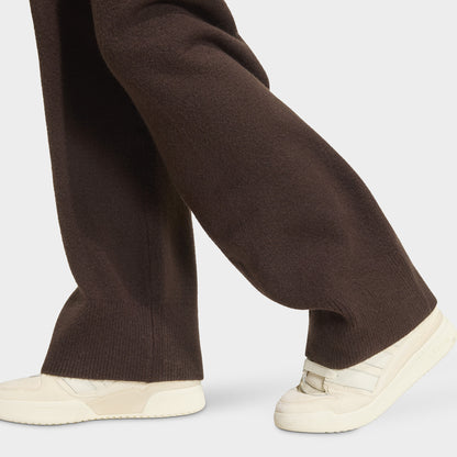adidas Essentials Knit Pant. Close-up of aurora coffee pants showing wide-leg hems and textured knit fabric.