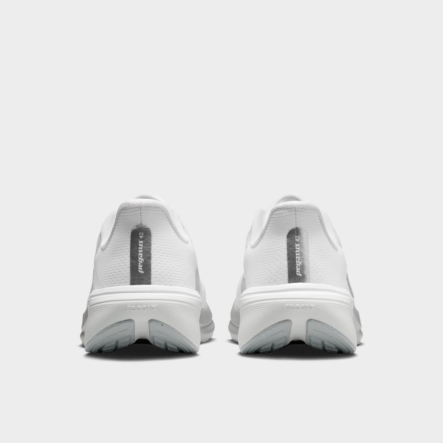 Nike Women's Pegasus 42. Rear view of white, metallic silver and wolf grey running shoes with padded heel panels and sculpted soles.