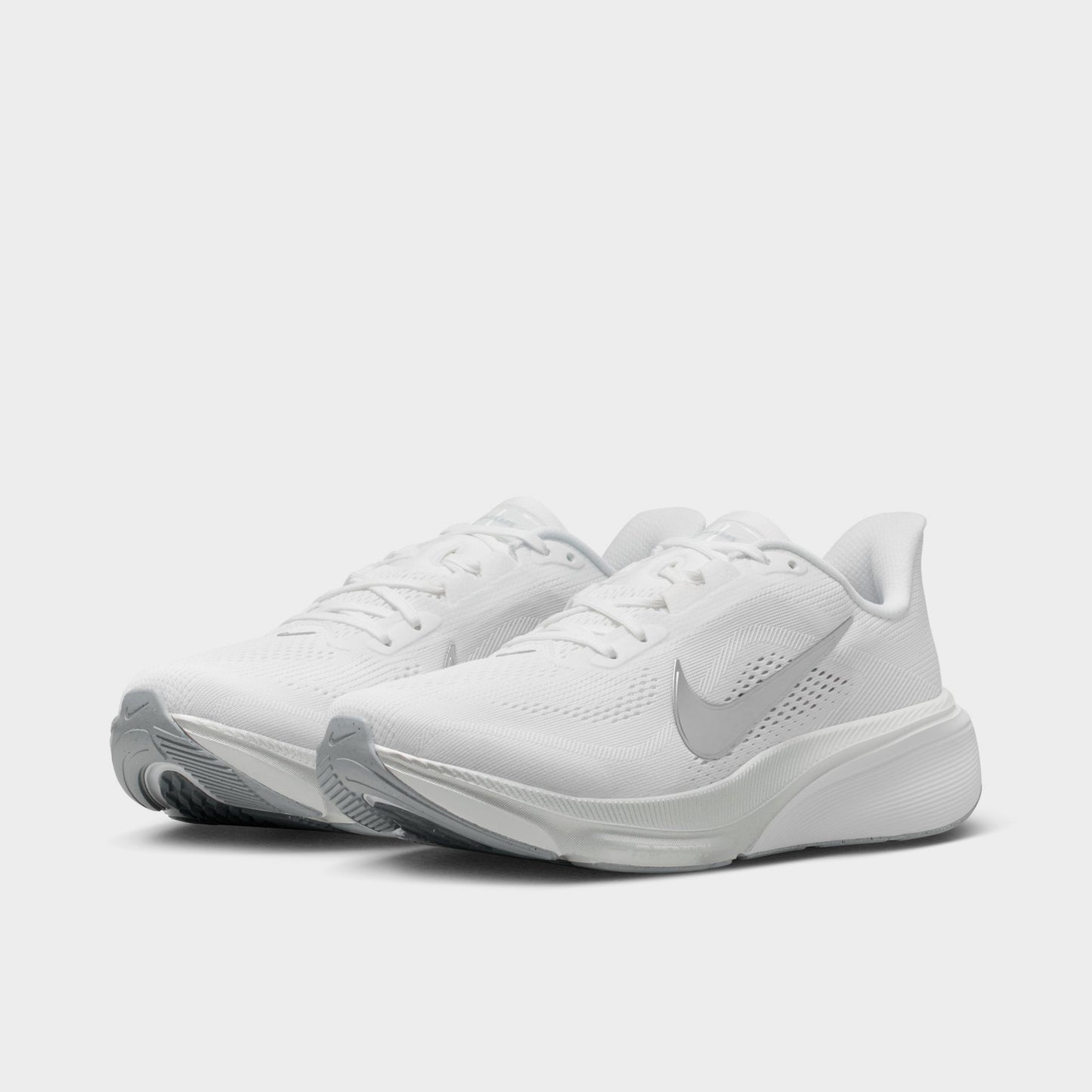 Nike Women's Pegasus 42. Three-quarter view of white, metallic silver and wolf grey running shoes with white laces, silver Swooshes and layered soles.