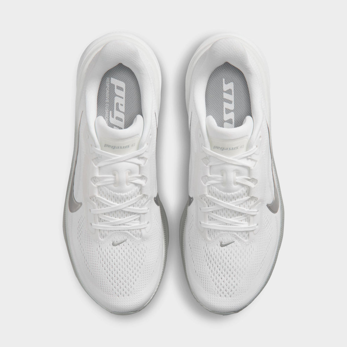 Nike Women's Pegasus 42. Top view of white, metallic silver and wolf grey running shoes showing white laces, padded tongues and mesh toe boxes.