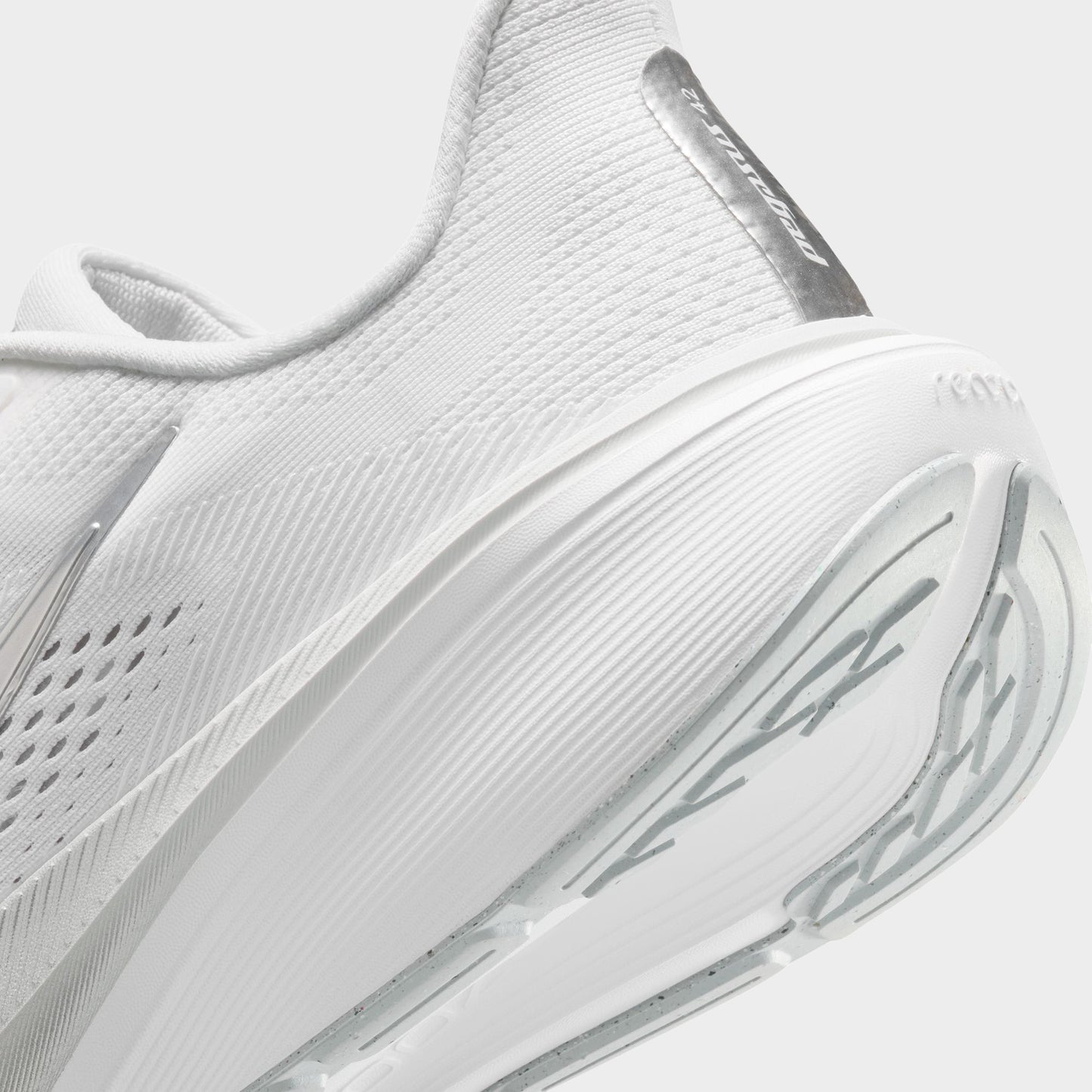 Nike Women's Pegasus 42. Close-up of white, metallic silver and wolf grey running shoe showing padded heel, reflective strip and layered midsole.
