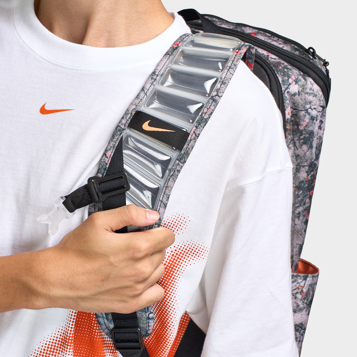 Nike Varsity Elite Backpack. Close-up of cream and black backpack showing padded shoulder strap, adjustable webbing and textured hardware.