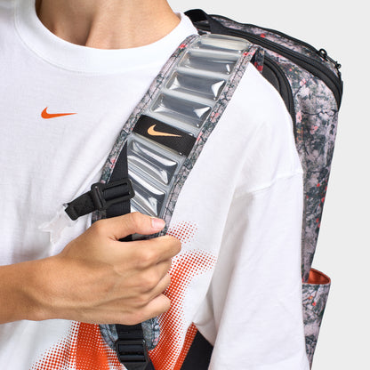 Nike Varsity Elite Backpack. Close-up of cream and black backpack showing padded shoulder strap, adjustable webbing and textured hardware.