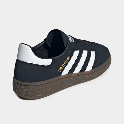 adidas Juniors' Handball Spezial. Rear three-quarter view of black, white and gum junior sneaker with white heel tab, padded collar and gum sole.