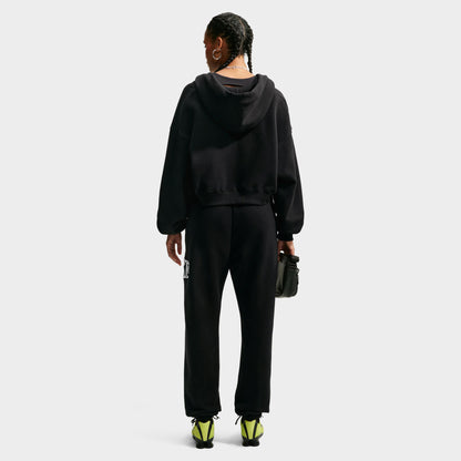 Nike Studio Fleece Cropped Full Zip Hoodie. Full-body back view of model wearing black cropped hoodie with matching black pants.
