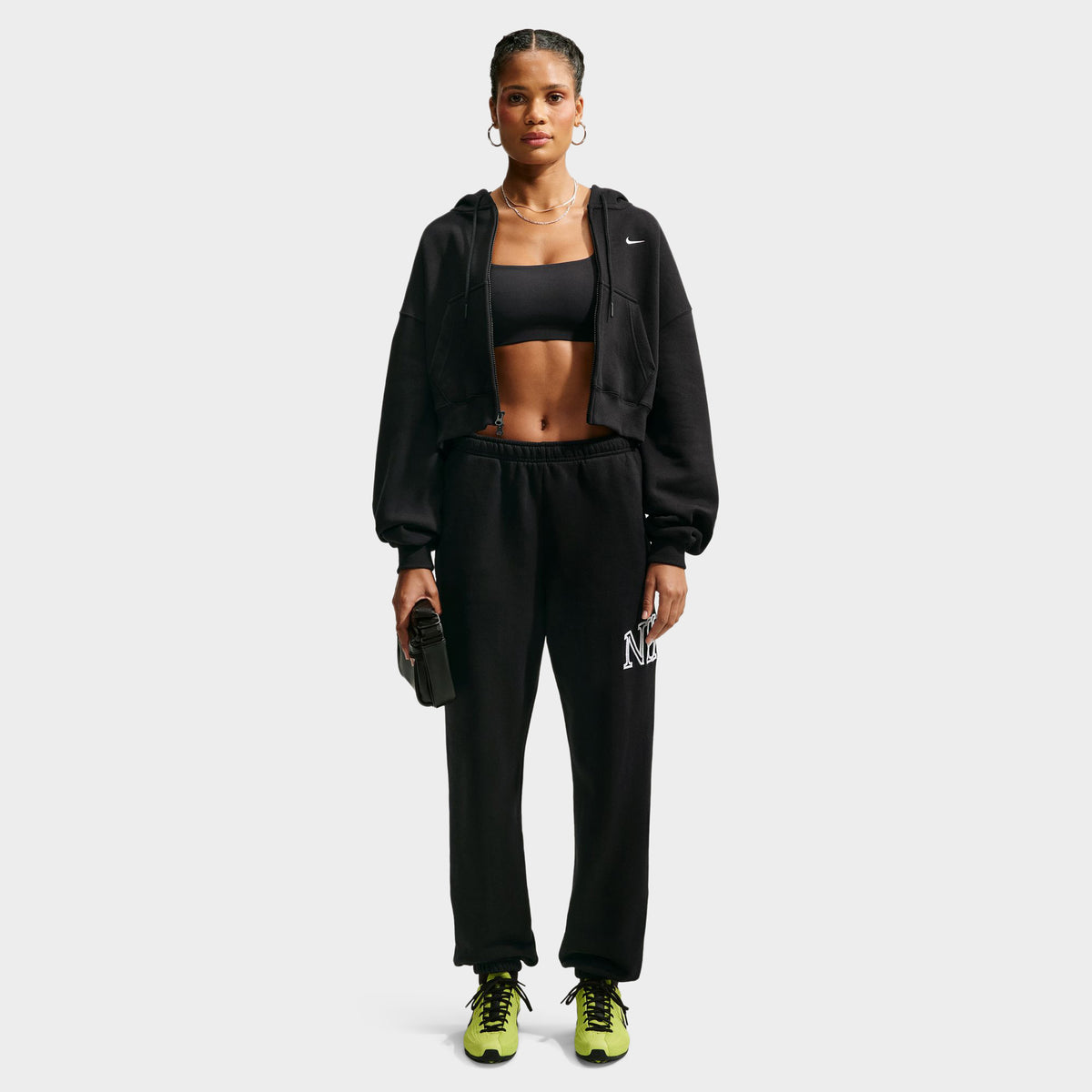 Nike Studio Fleece Cropped Full Zip Hoodie. Full-body front view of model wearing black cropped hoodie with matching black pants.