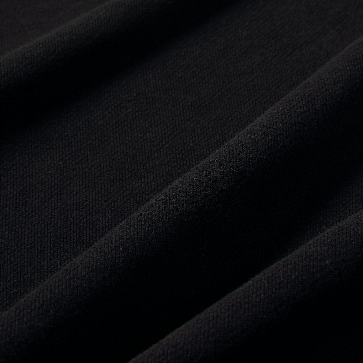 Nike Studio Fleece Cropped Full Zip Hoodie. Close-up of black fleece fabric showing the smooth brushed texture.