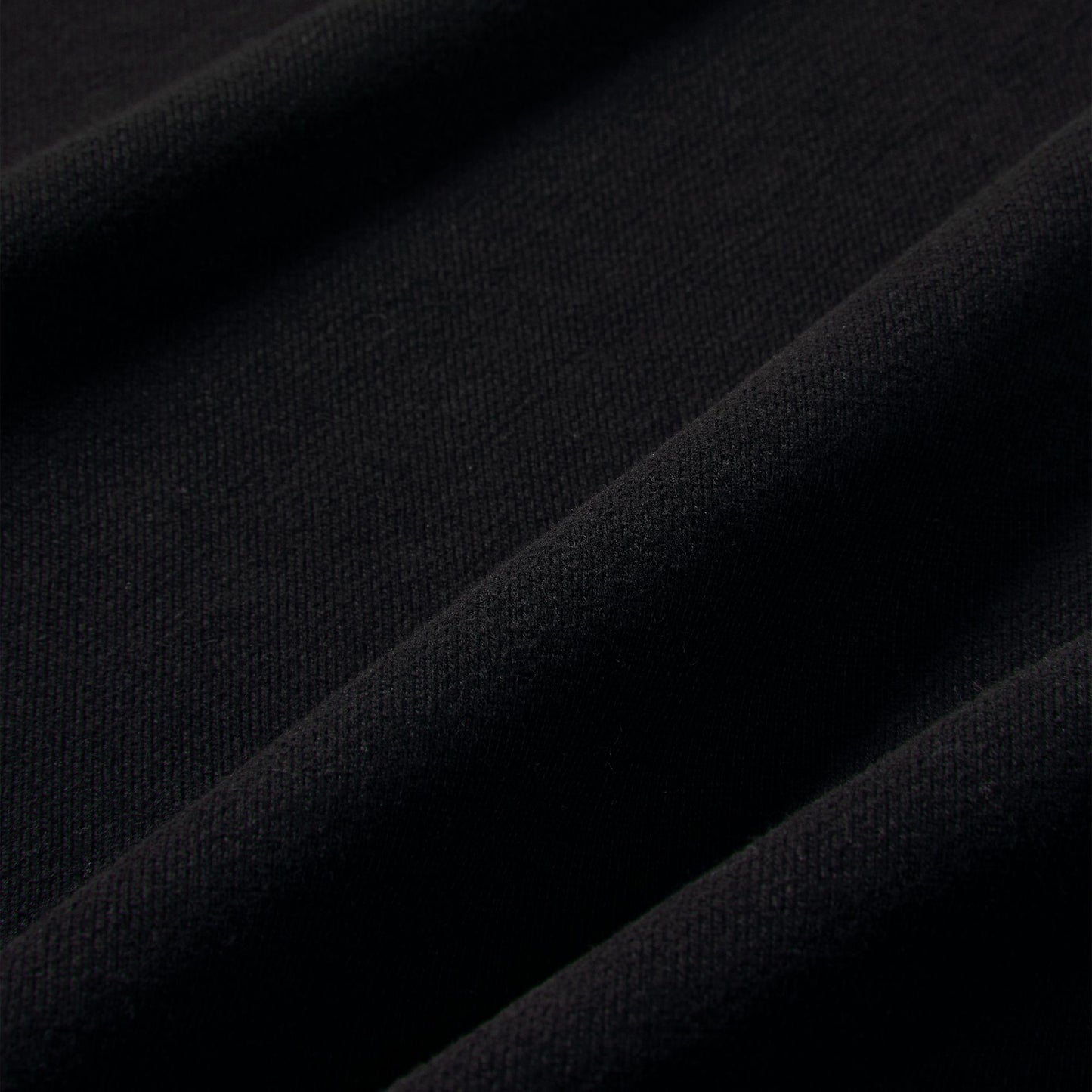 Nike Studio Fleece Cropped Full Zip Hoodie. Close-up of black fleece fabric showing the smooth brushed texture.