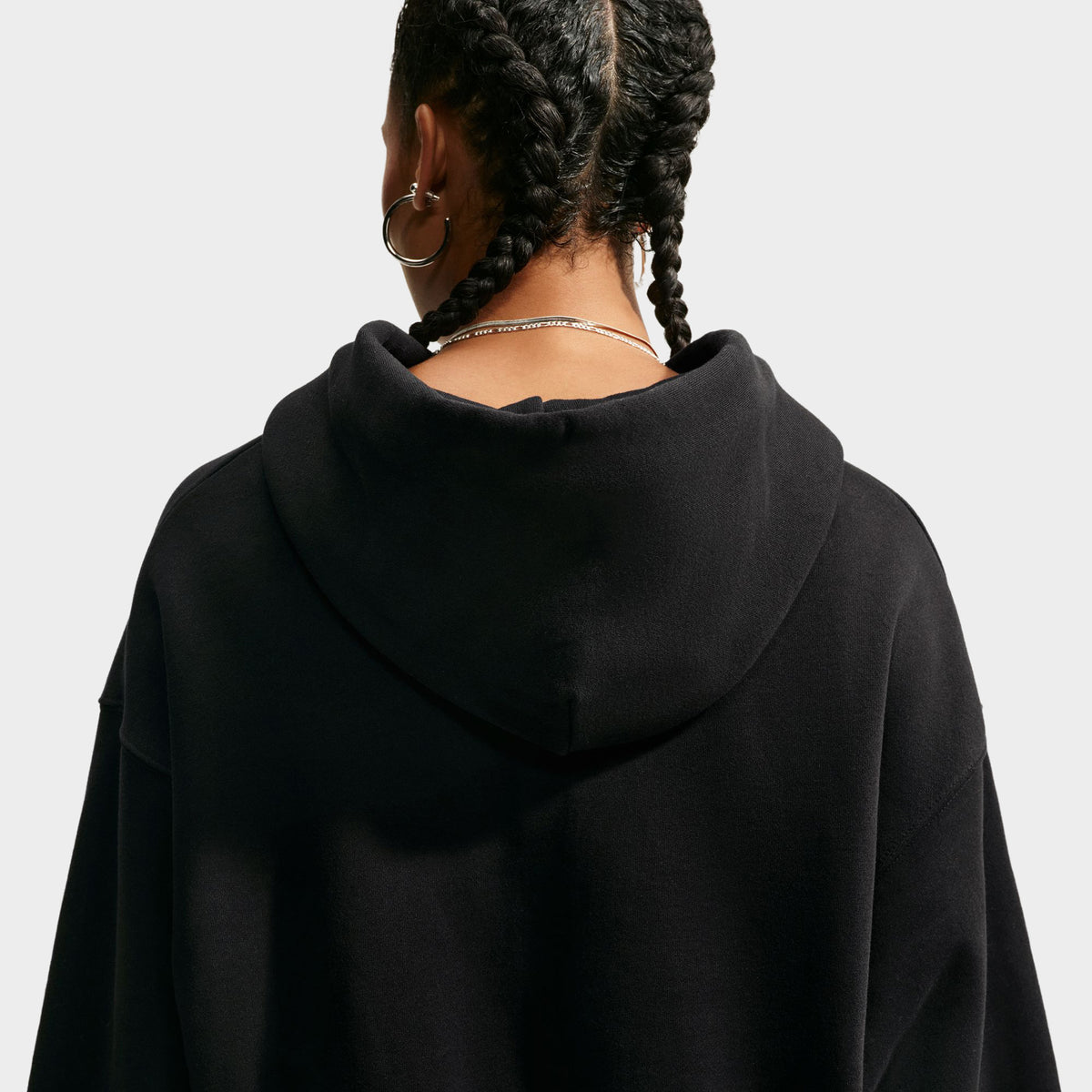 Nike Studio Fleece Cropped Full Zip Hoodie. Back view of black cropped hoodie showing the hood, dropped shoulders and relaxed silhouette.