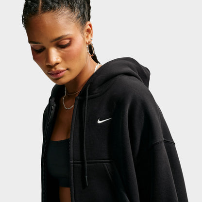 Nike Studio Fleece Cropped Full Zip Hoodie. Three-quarter view of model wearing black cropped hoodie with full-zip closure and small white Nike Swoosh.