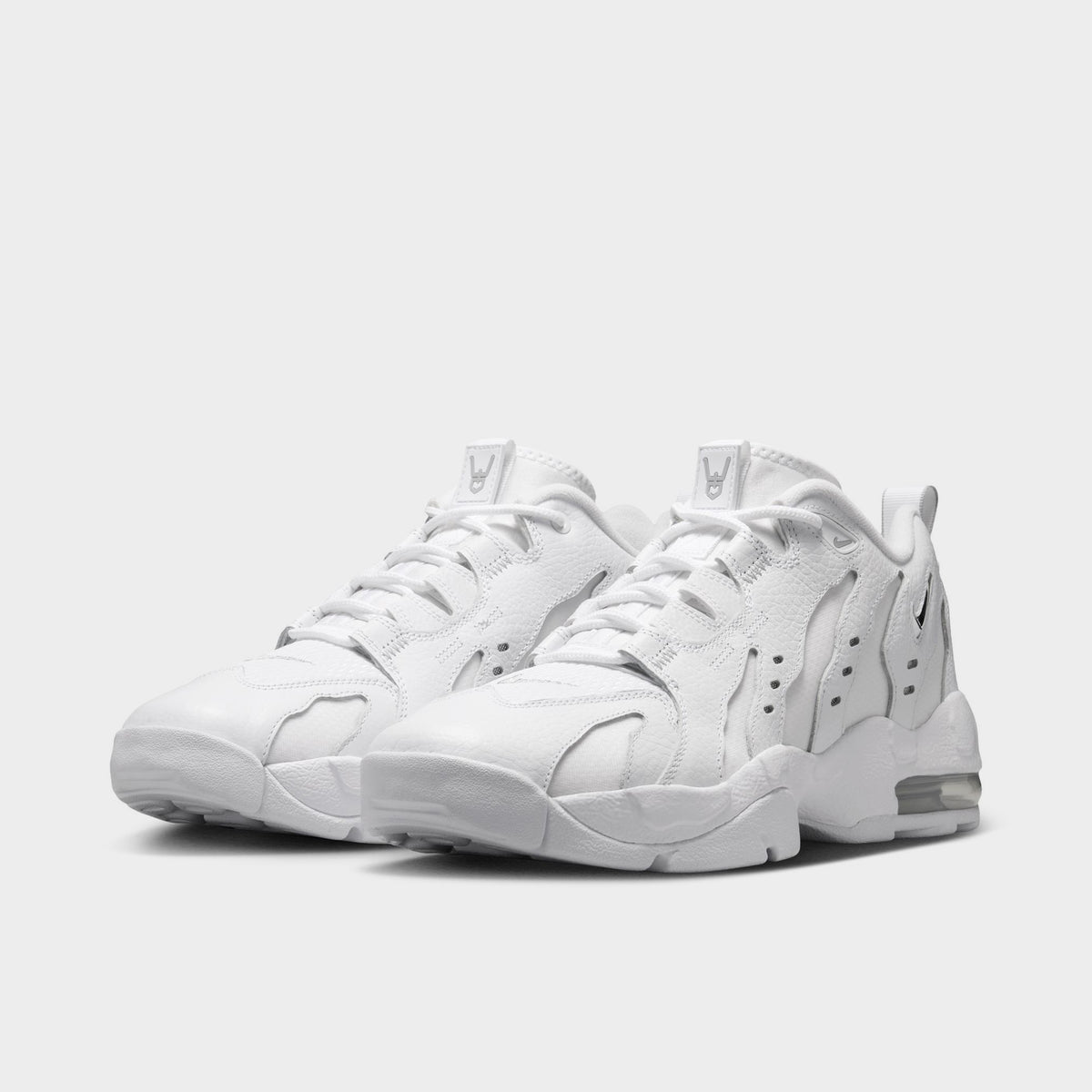 Nike Air DT Max '96 Low. Three-quarter view of white and metallic silver sneakers with white laces, layered uppers and visible Air units.