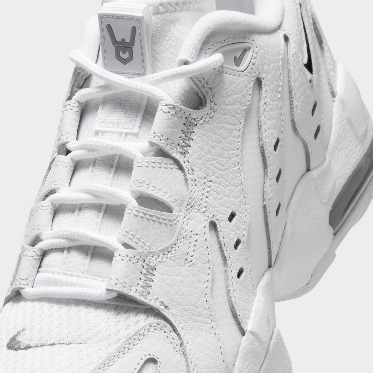 Nike Air DT Max '96 Low. Close-up of white and metallic silver sneaker showing white laces, layered panels and perforated upper details.