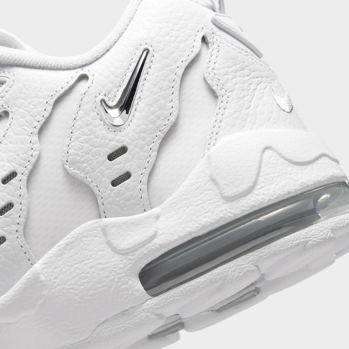 Nike Air DT Max '96 Low. Close-up of white and metallic silver sneaker showing sculpted heel panels and visible Air cushioning.