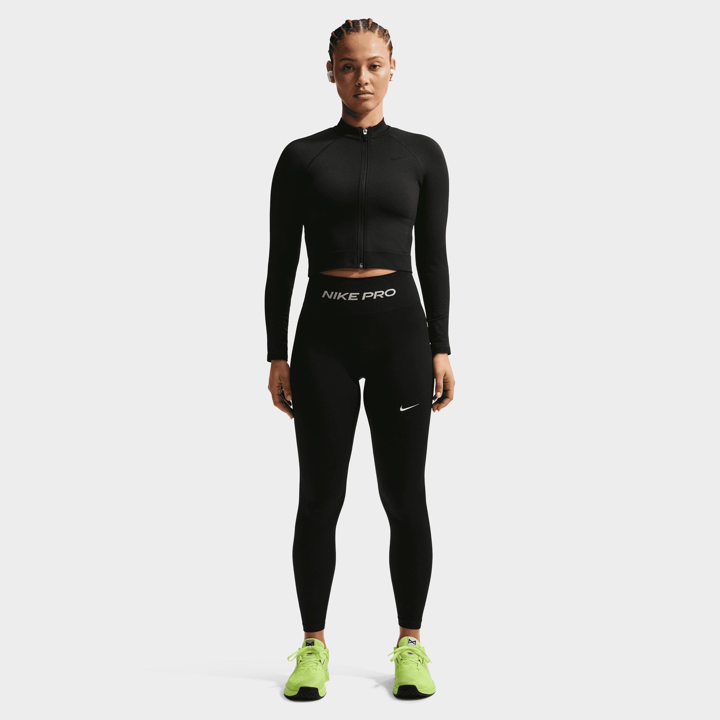 Nike Pro Women's Dry Fit Seamless Fullzip. Front view of model wearing black full-zip top with high collar, long sleeves and fitted silhouette.
