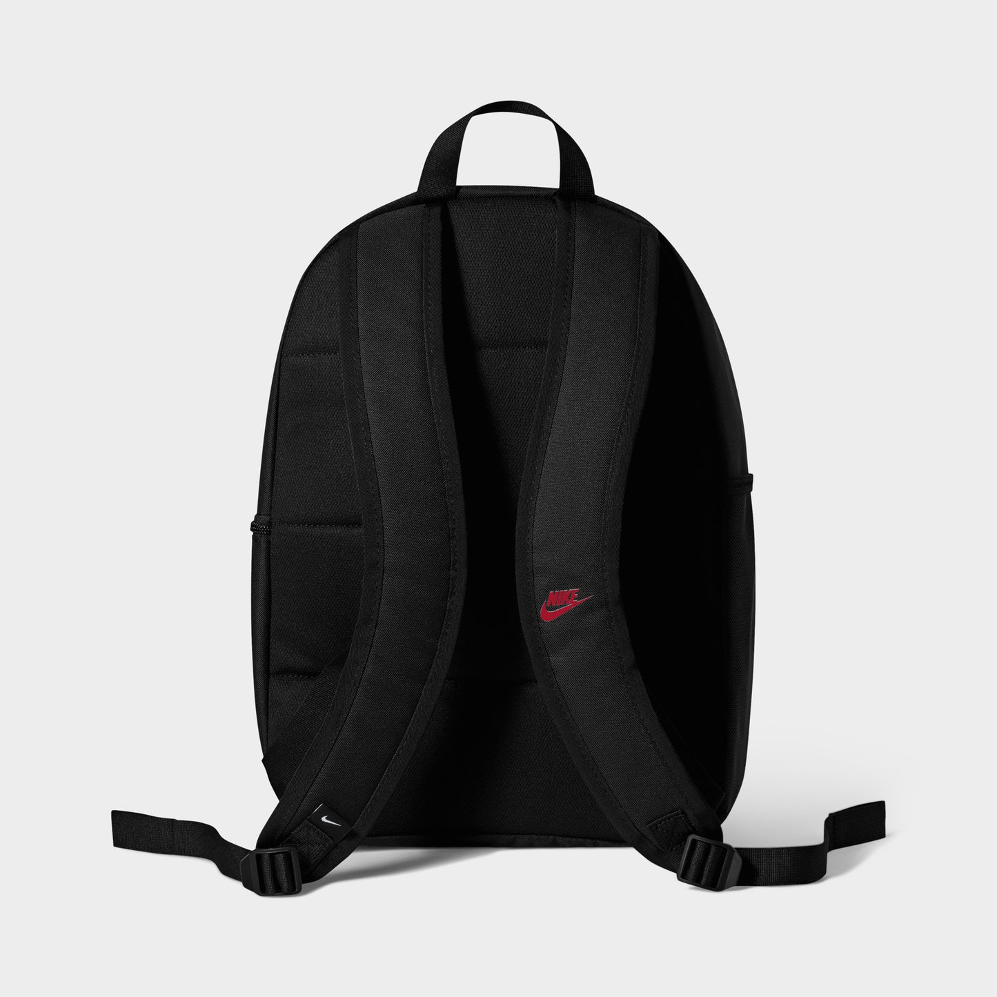 Nike AF1 Heritage Backpack. Back view of black backpack showing padded shoulder straps, top carry handle and red logo detail.