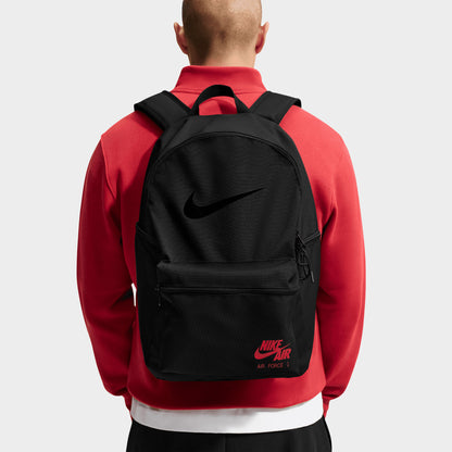 Nike AF1 Heritage Backpack. Back view of model wearing black backpack with padded shoulder straps and red Nike branding.