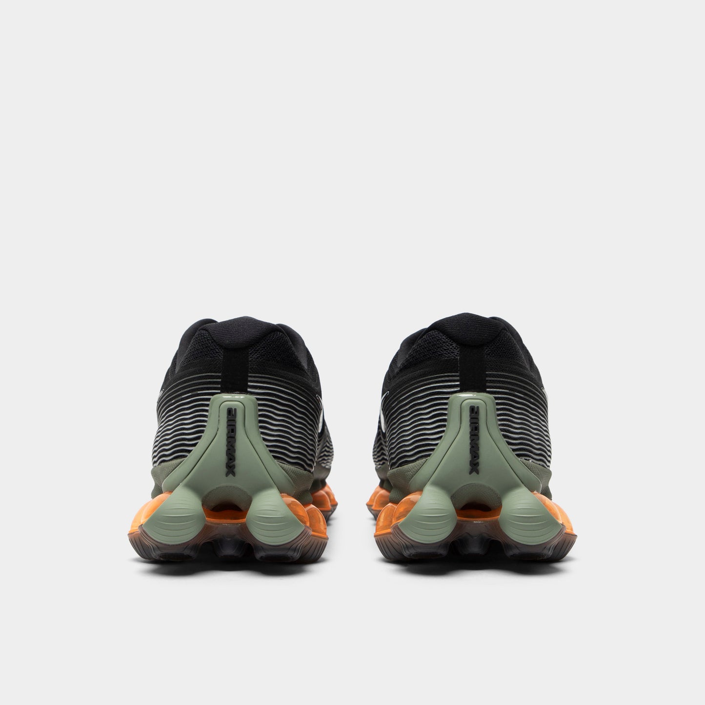 Nike Air Liquid Max. Rear view of black, metallic silver and light army sneakers with light army heel panels, heel pull tabs and amber Air soles.