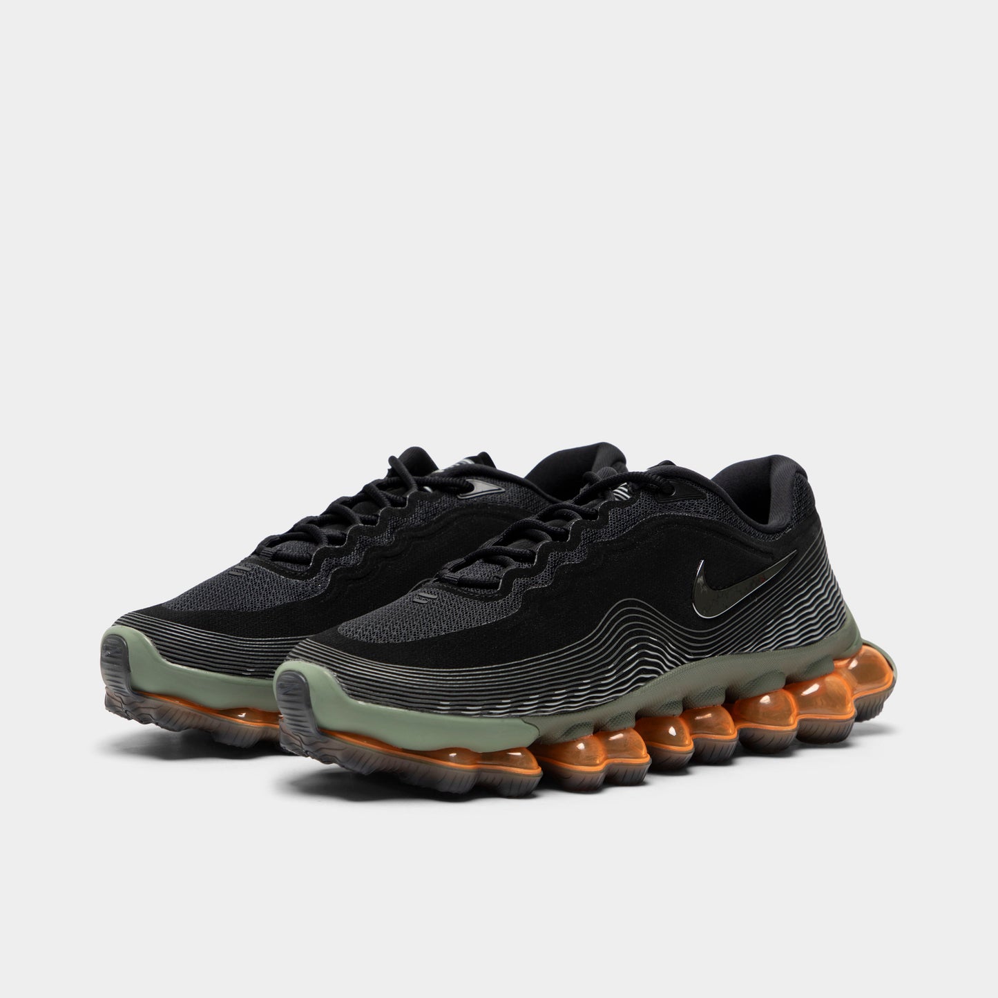 Nike Air Liquid Max. Three-quarter view of black, metallic silver and light army sneakers with black laces, sculpted uppers and amber full-length Air soles.