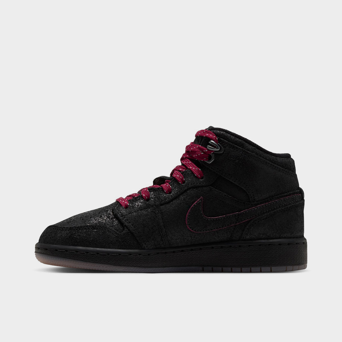 Jordan 1 Mid SE GS. Lateral side view featuring black textured upper, team red outlines around Swoosh, black midsole, and gum medium brown outsole. 