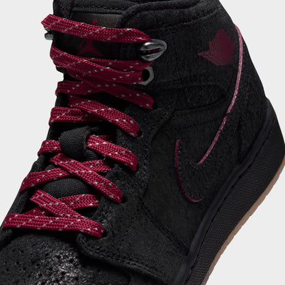 Jordan 1 Mid SE GS. Close-up front view highlighting team red patterned laces, metallic metal lace eyelets, and black textured leather overlays. 