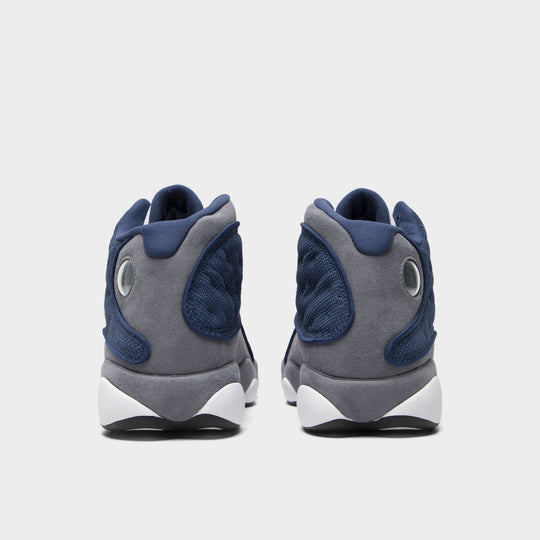 Jordan 13 Retro. Rear view of navy and university blue basketball sneakers with grey heel panels, padded collars and white sole sections.