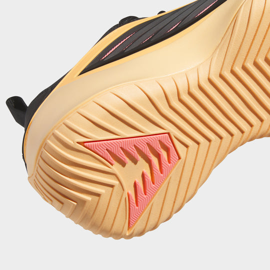 adidas Juniors' Believe That 1. Close-up of acid orange and core black junior basketball shoe showing the textured orange outsole and red traction pattern.