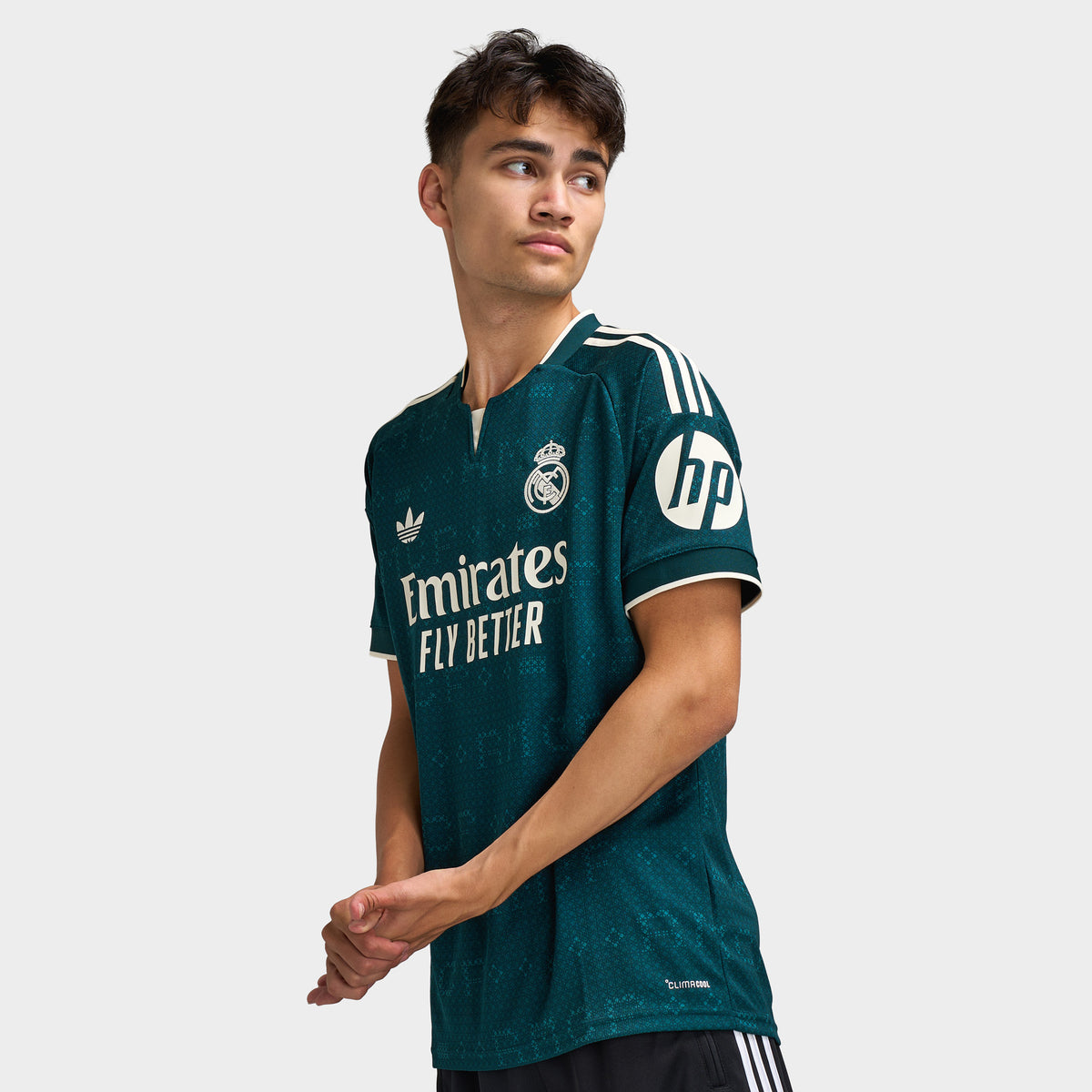 adidas Real Madrid Away Jersey. Three-quarter view of model wearing aurora ivy soccer jersey with white branding and sponsor graphic.