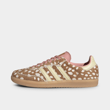 adidas Originals Women's Samba OG. Side view of low-top sneakers featuring a brown desert deer-print ponyhair upper with spotted details, warm vanilla leather Three-Stripes branding, warm vanilla heel tab, dusty pink tongue and lining, and a classic low-profile gum rubber sole unit. 