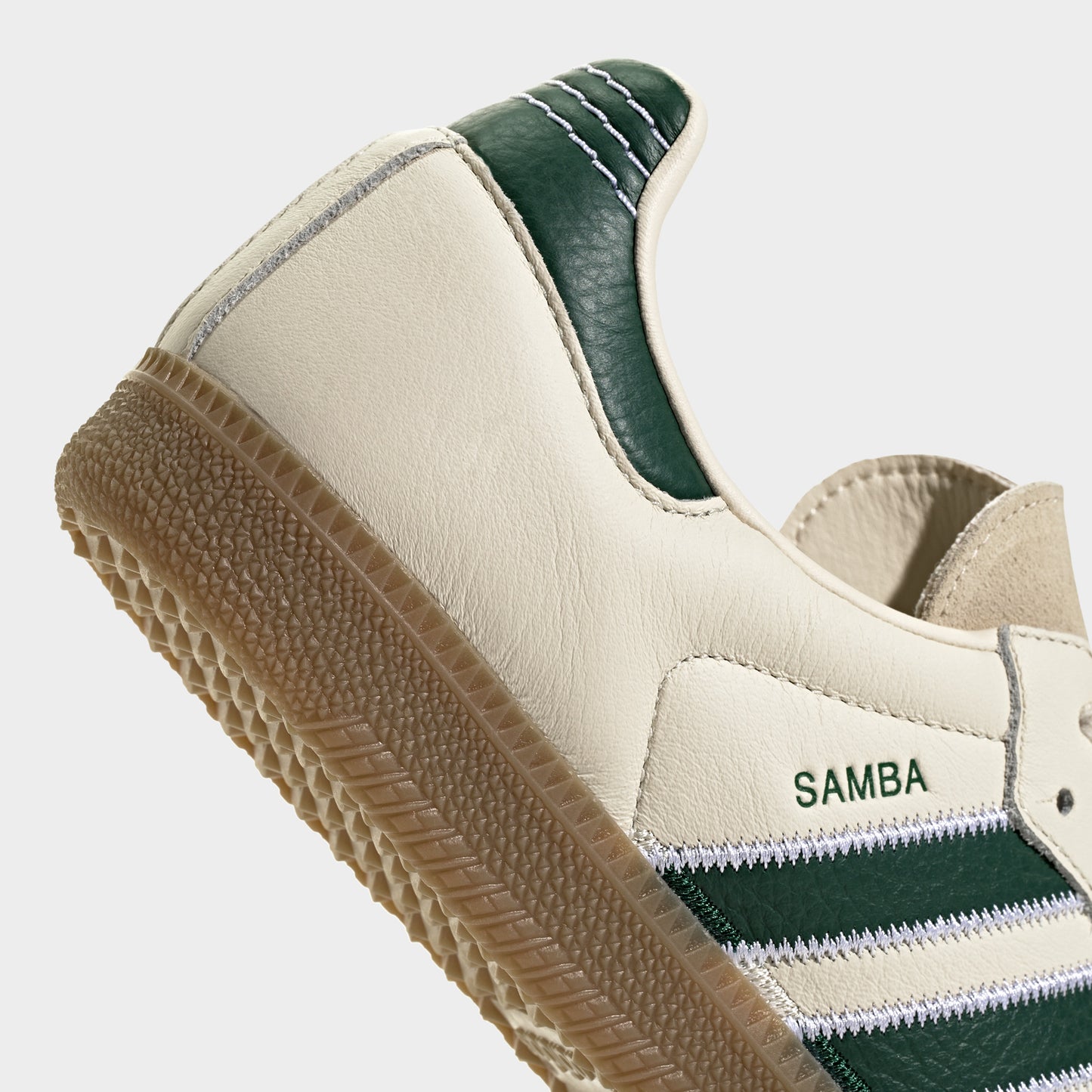 adidas Samba OG. Close-up of cream, collegiate green and gum sneaker showing green heel tab, padded collar and textured gum sole edge.
