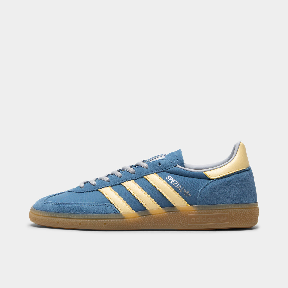 adidas Handball Spezial. Side view of dusky ink, easy yellow and gum sneaker with yellow three stripes, suede upper and gum sole.