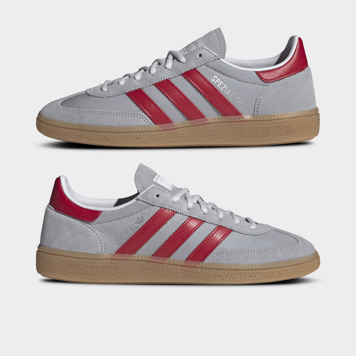 adidas Handball Spezial. Side view of halo silver, team victory red and gum sneakers with red three stripes, layered uppers and gum soles.