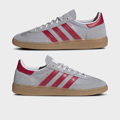 adidas Handball Spezial. Side view of halo silver, team victory red and gum sneakers with red three stripes, layered uppers and gum soles.