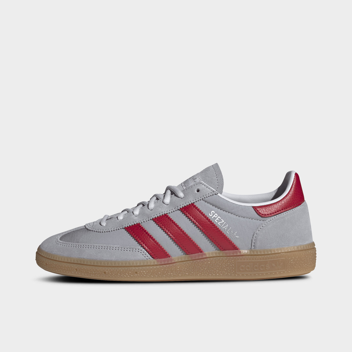 adidas Handball Spezial. Side view of halo silver, team victory red and gum sneaker with red three stripes, suede overlays and gum sole.
